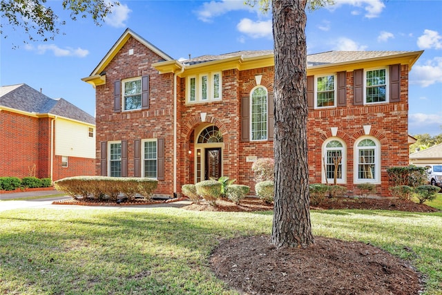 view of front of house with brick siding and a front lawn