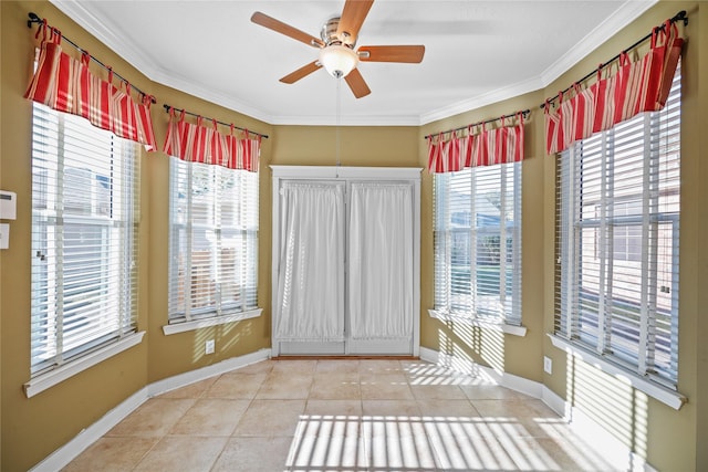 interior space featuring tile patterned flooring, ceiling fan, baseboards, and ornamental molding