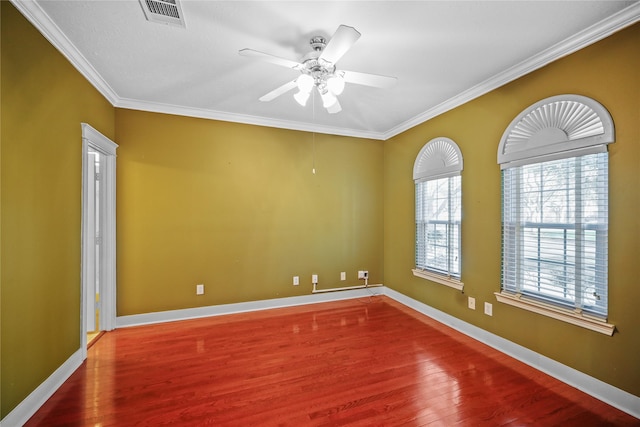 unfurnished room with visible vents, baseboards, wood finished floors, and ornamental molding