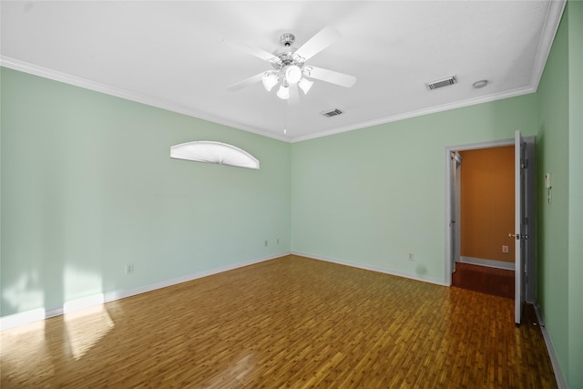 empty room featuring a ceiling fan, wood finished floors, visible vents, baseboards, and crown molding