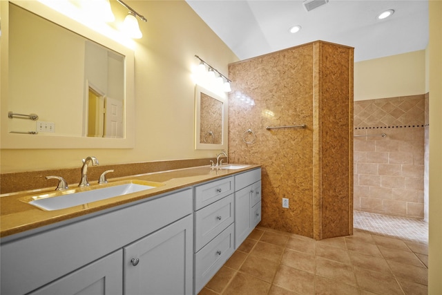 bathroom with a sink, walk in shower, tile patterned floors, and double vanity