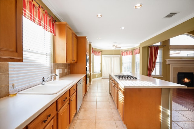 9406 Laurel Wind Ct, Houston, TX 77040 - kitchen with appliances with stainless steel finishes, light countertops, tasteful backsplash, a warm lit fireplace, and a center island