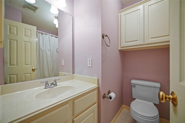 bathroom featuring visible vents, baseboards, toilet, tile patterned floors, and vanity