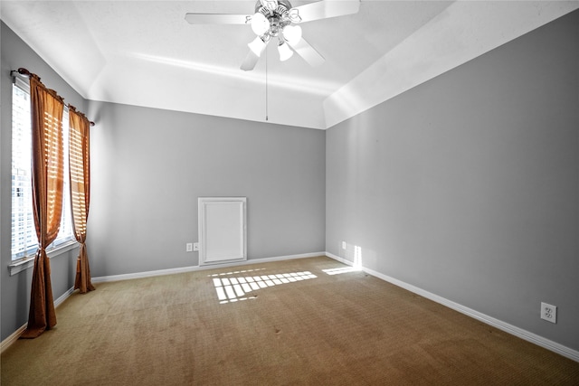 carpeted empty room with lofted ceiling, baseboards, and ceiling fan