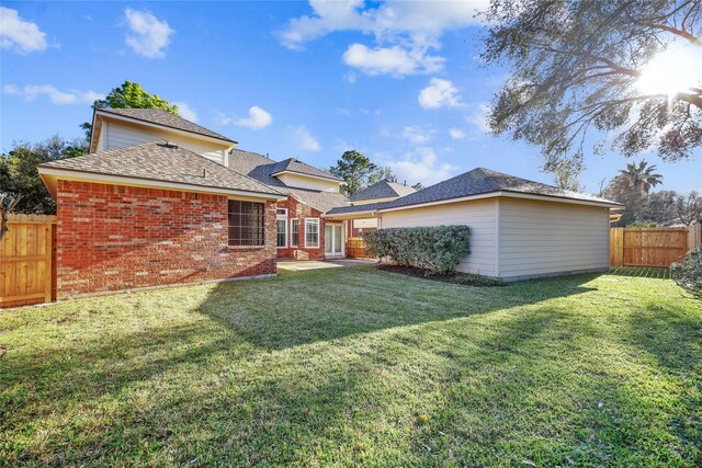9406 Laurel Wind Ct, Houston, TX 77040 - back of house with a fenced backyard, brick siding, and roof with shingles