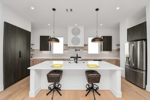 kitchen featuring modern cabinets, visible vents, stainless steel fridge with ice dispenser, and open shelves