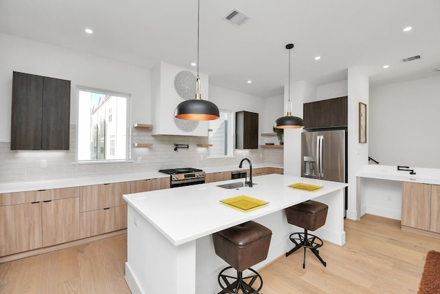 kitchen featuring visible vents, modern cabinets, appliances with stainless steel finishes, open shelves, and a sink