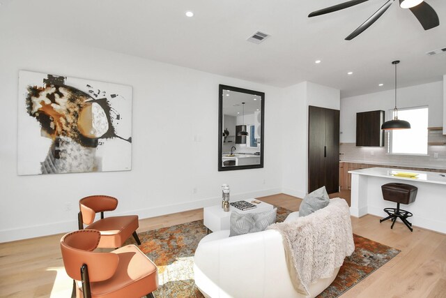 living area featuring baseboards, visible vents, a ceiling fan, light wood-style floors, and recessed lighting