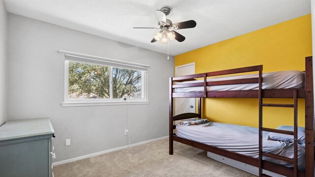 carpeted bedroom featuring baseboards and a ceiling fan