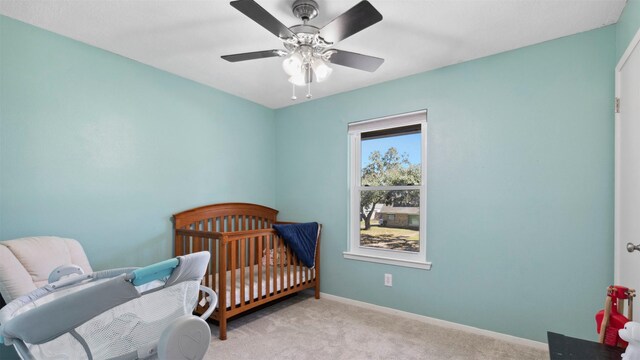 carpeted bedroom with a ceiling fan and baseboards