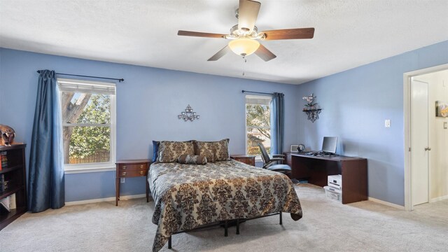 carpeted bedroom featuring ceiling fan and baseboards