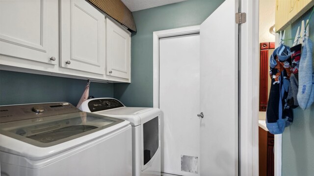 washroom with cabinet space and washer and dryer