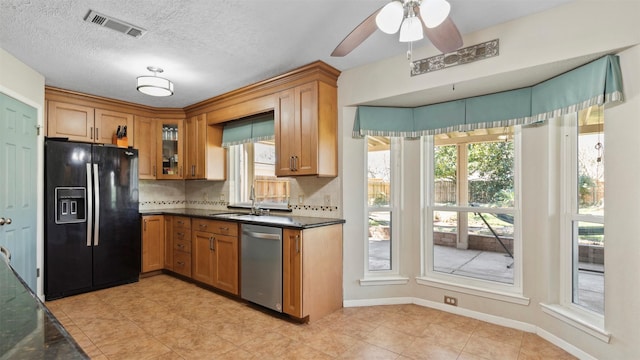 kitchen featuring tasteful backsplash, visible vents, black refrigerator with ice dispenser, a sink, and dishwasher