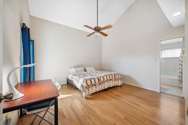 bedroom with lofted ceiling, light wood-style flooring, and baseboards