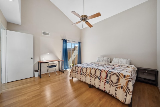 bedroom featuring high vaulted ceiling, a ceiling fan, visible vents, and wood finished floors