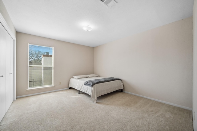 unfurnished bedroom with carpet floors, baseboards, visible vents, and a closet