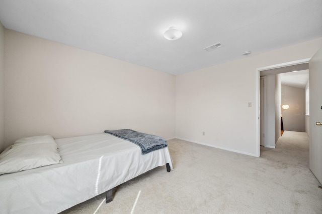 bedroom with baseboards, visible vents, and light colored carpet