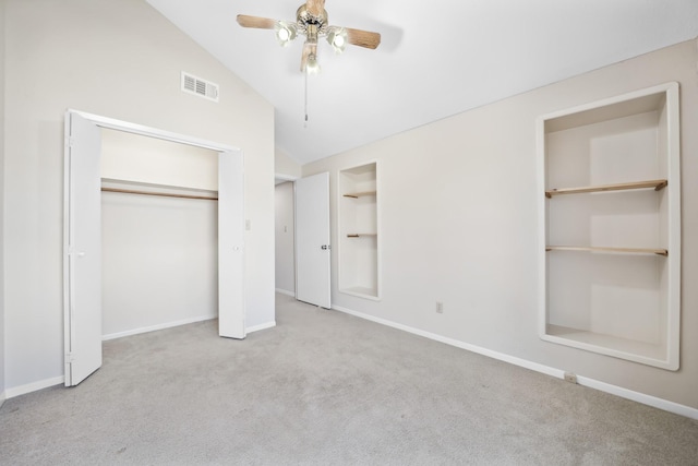 unfurnished bedroom with baseboards, visible vents, vaulted ceiling, carpet floors, and a closet