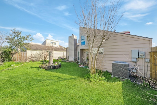 view of yard featuring fence and central AC unit