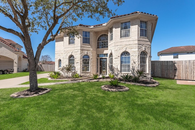 view of front facade with fence, driveway, and a front lawn