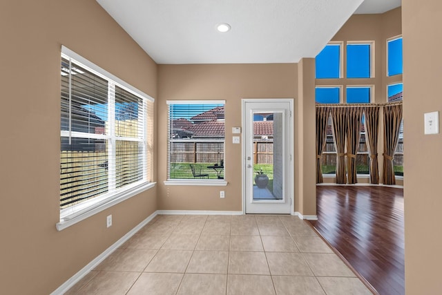 doorway to outside with tile patterned flooring and baseboards