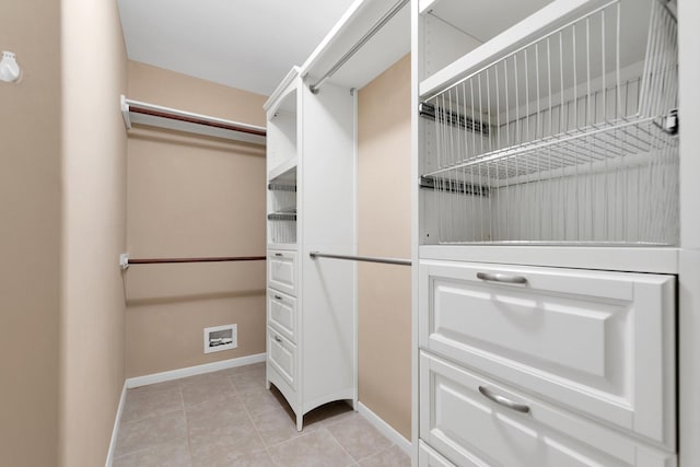 walk in closet with light tile patterned flooring