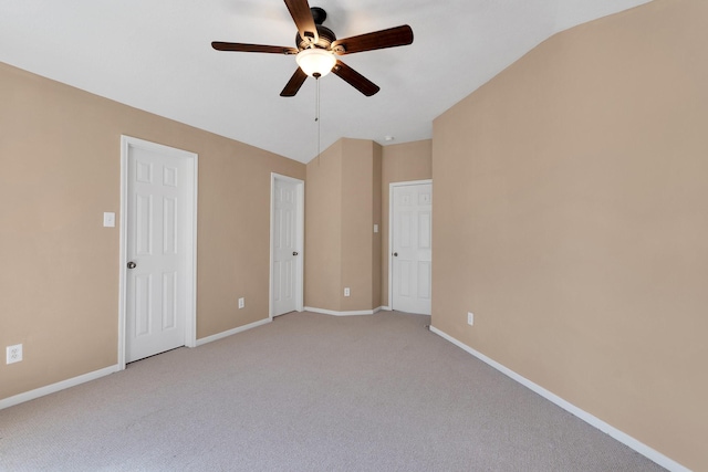 unfurnished bedroom featuring lofted ceiling, ceiling fan, light carpet, and baseboards