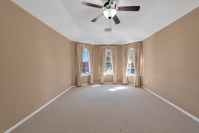 empty room featuring baseboards, visible vents, a ceiling fan, and light colored carpet