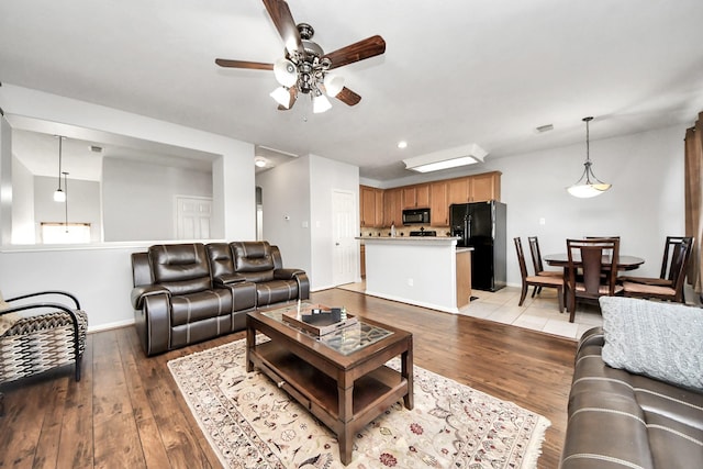 10138 W Palm Lake Dr, Houston, TX 77034 - living room featuring light wood-style floors, baseboards, visible vents, and ceiling fan