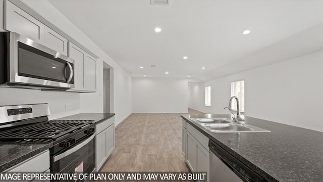 kitchen featuring stainless steel appliances, recessed lighting, a sink, and light wood-style floors