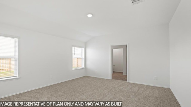 empty room with lofted ceiling, carpet flooring, visible vents, and baseboards