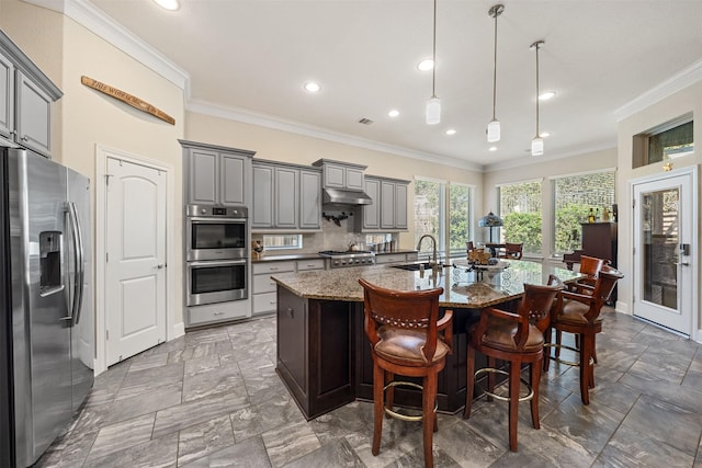 kitchen with ornamental molding, gray cabinets, a sink, stainless steel appliances, and decorative backsplash