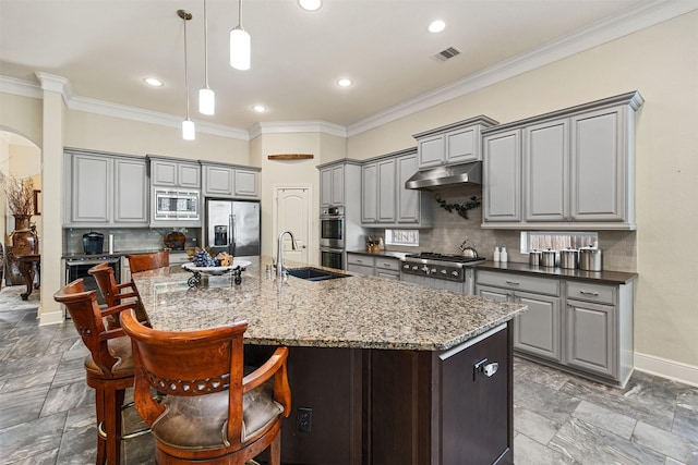 kitchen with visible vents, gray cabinets, a sink, stainless steel appliances, and arched walkways