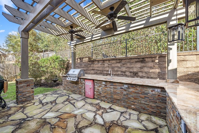 view of patio with grilling area, fence, exterior kitchen, a pergola, and a ceiling fan