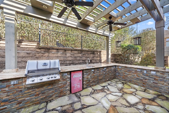 view of patio / terrace featuring area for grilling, a ceiling fan, a pergola, fence, and an outdoor kitchen