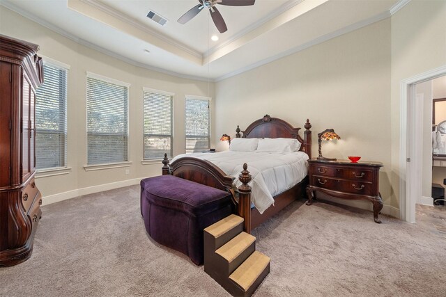 carpeted bedroom with visible vents, crown molding, ceiling fan, baseboards, and a tray ceiling