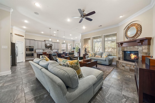 living area with stone tile floors, recessed lighting, crown molding, and baseboards