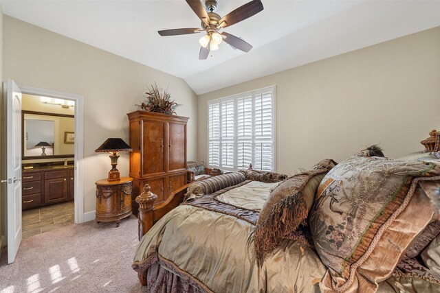 bedroom featuring connected bathroom, baseboards, vaulted ceiling, light carpet, and a ceiling fan