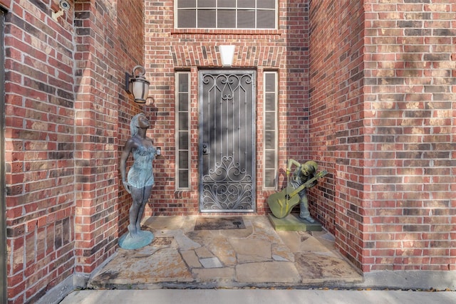 view of exterior entry with brick siding