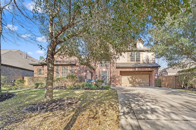 view of front facade featuring brick siding, driveway, an attached garage, and fence