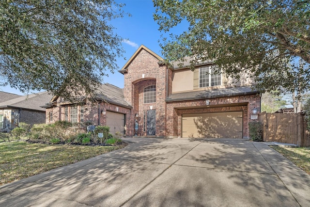 traditional-style house featuring concrete driveway, an attached garage, fence, and brick siding