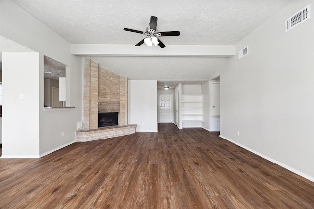 unfurnished living room with vaulted ceiling with beams, a brick fireplace, and visible vents