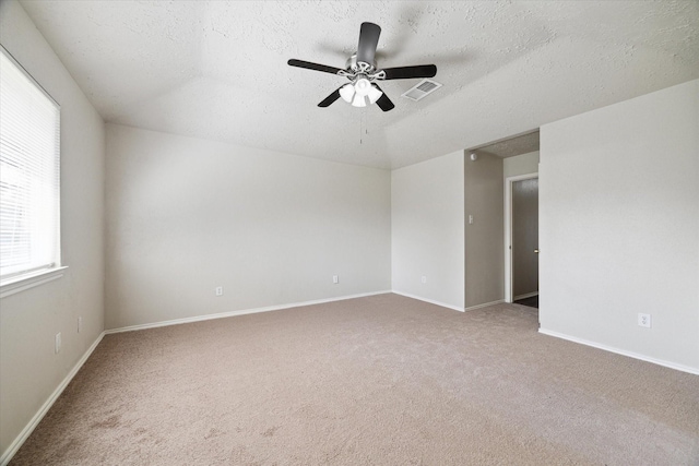 unfurnished room featuring a textured ceiling, carpet floors, visible vents, and baseboards