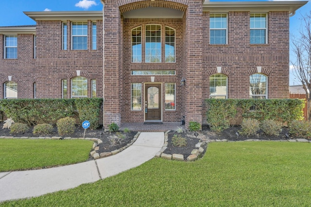 view of front of home featuring a front lawn and brick siding