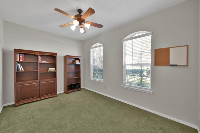 empty room featuring carpet flooring, a ceiling fan, and baseboards