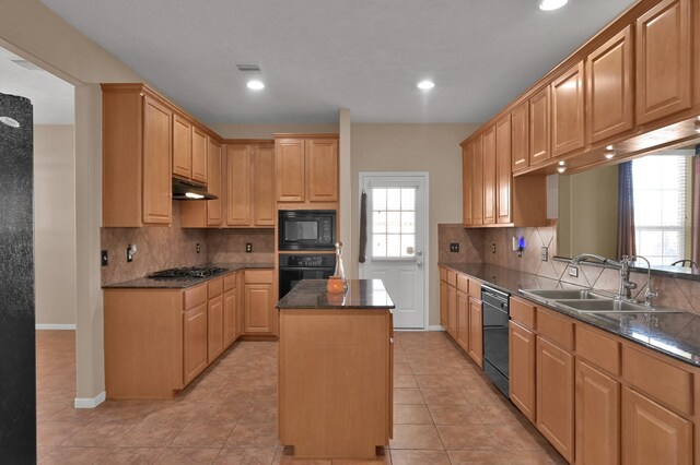 kitchen with visible vents, a kitchen island, a sink, black appliances, and under cabinet range hood