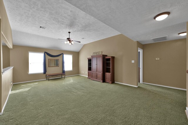 carpeted empty room with lofted ceiling, baseboards, and visible vents