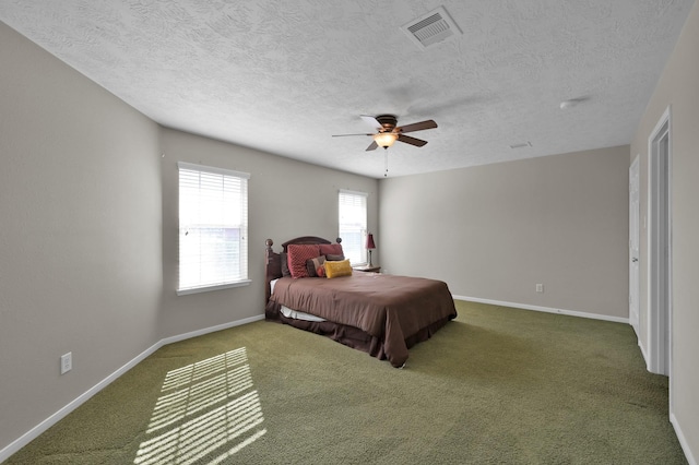 carpeted bedroom featuring visible vents, a textured ceiling, a ceiling fan, and baseboards