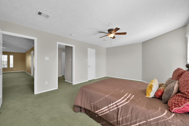 bedroom with baseboards, visible vents, ceiling fan, a textured ceiling, and carpet flooring