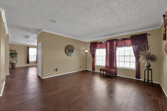 spare room featuring crown molding, baseboards, and wood finished floors